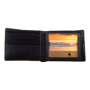 May include: Open black leather wallet with multiple card slots and a clear window. The window displays a sunset scene with a sailboat and text from Jeremiah 29:11. The wallet is open, showcasing its interior.