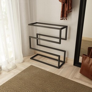 Black metal shoe organizer with a minimalist design, ideal for keeping shoes and umbrellas neatly stored