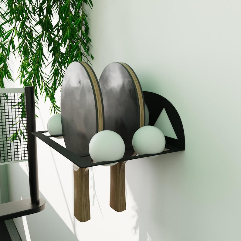 Table tennis paddle and ball wall rack in sleek black metal with Squid Game shapes, functional and decorative storage solution