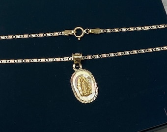 May include: A gold chain necklace with a pendant featuring a depiction of the Virgin Mary. The necklace is in a black box with the word "IOKA" printed on it.