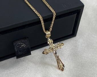 Op de afbeelding: Een gouden ketting met een twee-kleurige gouden kruis hanger met een gedetailleerde afbeelding van Jezus Christus.