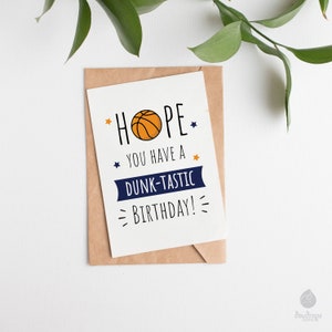 May include: A white card with a basketball graphic and the text "HOPE YOU HAVE A DUNK-TASTIC BIRTHDAY!"