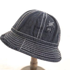 May include: A black denim bucket hat with white stitching and a distressed detail on the crown.