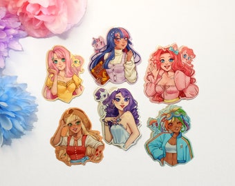 May include: Six colorful stickers featuring cartoon characters with pony tails and animal companions. The characters are wearing different outfits and have different hair colors. The stickers are on a white background.