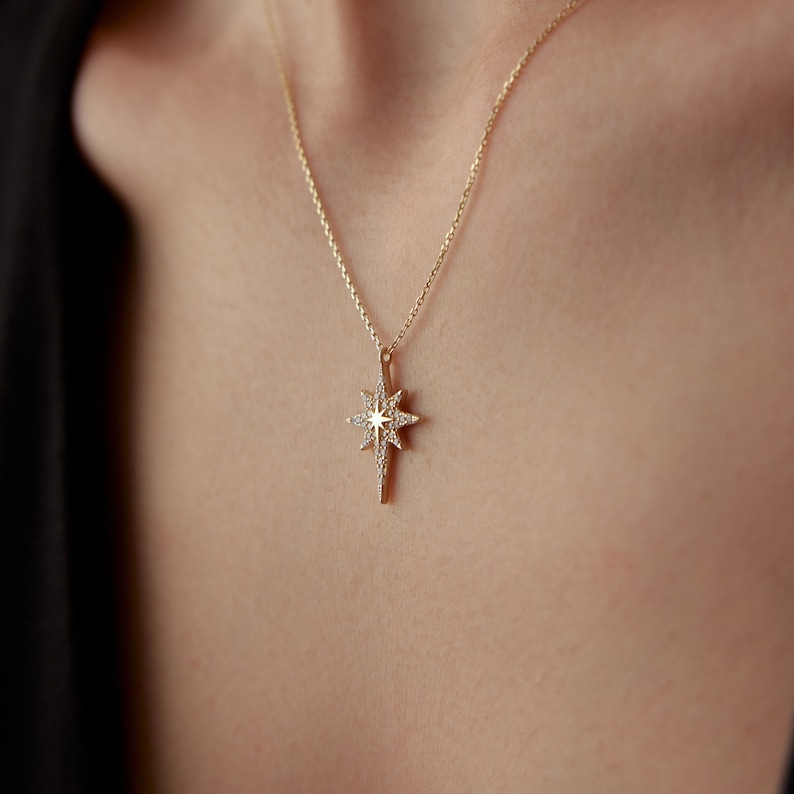 May include: A gold necklace with a star-shaped pendant encrusted with small diamonds.