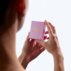 May include: A pink box with the text "ML made/love Brooklyn" in gold lettering.