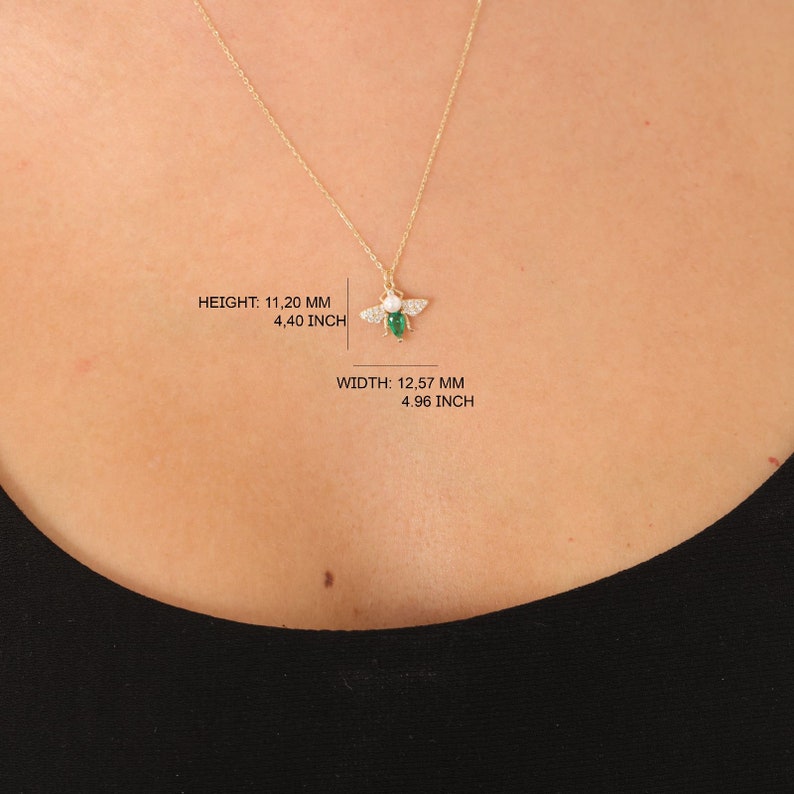Puede incluir: Collar con colgante de abeja de oro, con una piedra preciosa verde y acentos de circonita c&uacute;bica blanca. ALTURA: 11,20 MM 4,40 PULGADAS ANCHO: 12,57 MM 4,96 PULGADAS