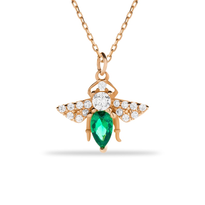 Puede incluir: Un collar de oro con un colgante de abeja con una piedra preciosa de esmeralda verde y piedras de circonita c&uacute;bica transparentes.