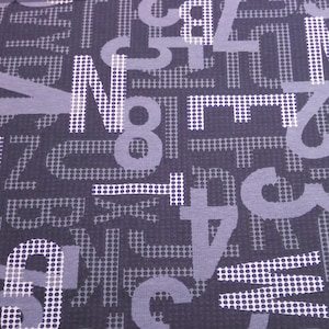 Könnte beinhalten: Ein dunkelvioletter Stoff mit einem weißen Muster aus überlappenden Zahlen und Buchstaben. Die Zahlen und Buchstaben sind auf einem Hintergrund aus kleinen weißen Punkten gedruckt.