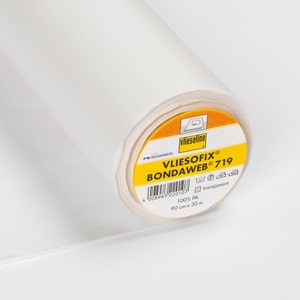 Könnte beinhalten: Eine Rolle weißer Vliesofix Bondaweb 719, ein transparentes Vlies zum Verkleben von Stoffen. Das Etikett ist gelb mit schwarzem Text und einem Barcode. Es ist 90 cm breit und 30 Meter lang.