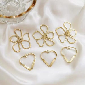 Conjunto de 10 peças de bases vazadas banhadas a ouro em formato de flor e coração para confecção de joias de resina (faça você mesmo).