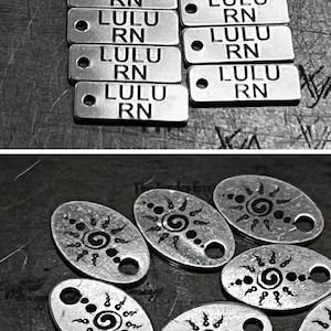 Puede incluir: Una colecci&oacute;n de dijes de metal plateado con varios dise&ntilde;os. Algunos dijes son redondos con la palabra "caro" grabada en ellos. Otros dijes son rectangulares con las palabras "LULU RN" grabadas en ellos. Tambi&eacute;n hay dijes ovalados con un dise&ntilde;o de sol y dijes en forma de coraz&oacute;n con las letras "JBP" grabadas en ellos.
