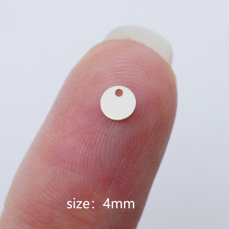 Puede incluir: Un peque&ntilde;o charm redondo de plata con un agujero en el centro. El charm tiene un di&aacute;metro de 4 mm.