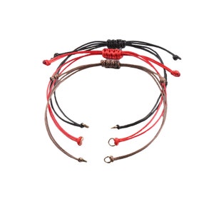 May include: Three braided bracelets in black, red, and brown with adjustable sliding knots and metal clasps.