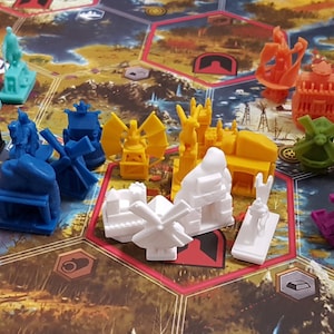 May include: A collection of 17 colorful plastic game pieces, each with a unique design. The pieces are arranged in a semi-circle on a brown and green game board. The pieces are in various colors, including red, blue, green, yellow, orange, purple, and white.