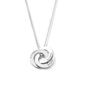 Op de afbeelding: Zilveren ketting met drie in elkaar grijpende ringen, elk gegraveerd met een naam: Isabella, Joshua en Robin.