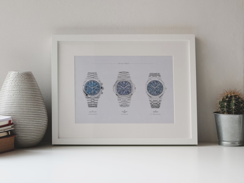 K&ouml;nnte beinhalten: Ein wei&szlig;er gerahmter Druck mit dem Titel "The Holy Trinity", der drei silberne Armbanduhren mit blauen Zifferbl&auml;ttern zeigt.