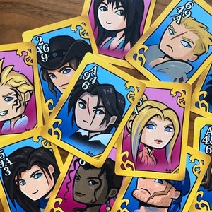 May include: A set of playing cards featuring characters from a video game. The cards are decorated with gold trim and have a blue, pink, or white background. Each card features a different character with a number and letter printed on the card.