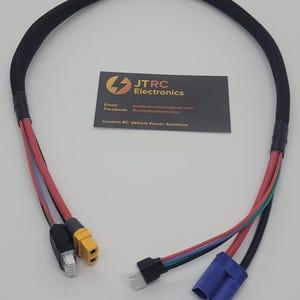 Puede incluir: Un cable negro con un conector amarillo y negro en un extremo y un conector azul en el otro extremo. El cable está cubierto con una funda trenzada negra. El cable está etiquetado con el texto "JTRC Electronics" y la información de contacto.