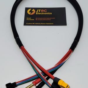 Puede incluir: Un mazo de cables negro con varios cables de colores, incluyendo rojo, blanco, azul y verde. El mazo tiene un conector negro en un extremo y un conector amarillo en el otro extremo. El mazo está etiquetado con el texto "JTRC Electronics".