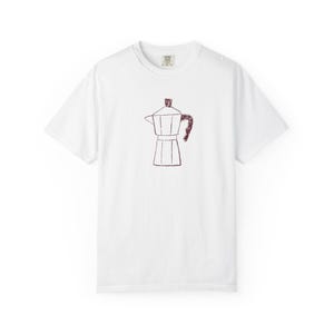 Könnte beinhalten: Weißes T-Shirt mit einer bordeauxfarbenen Illustration einer Espressokanne. Die Grafik ist eine einfache Strichzeichnung des Kaffeezubereiters. Das Shirt hat einen Rundhalsausschnitt und kurze Ärmel, perfekt für den Alltag.