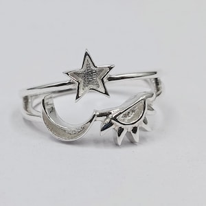 May include: A silver ring with a crescent moon, a star, and a sun design.