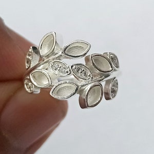 K&ouml;nnte beinhalten: Ein silberner Ring mit einem Design aus Bl&auml;ttern und kleinen klaren Steinen.