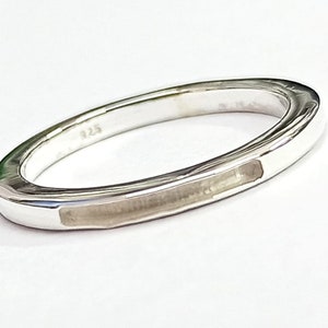Op de afbeelding: Een zilveren ring met een platte, rechthoekige band en een gladde, gepolijste afwerking. De ring is aan de binnenkant gemarkeerd met het nummer "125".