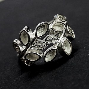K&ouml;nnte beinhalten: Silberring mit einem Blattdesign und klaren Steinen. Der Ring ist aus Metall gefertigt und hat einen zarten, femininen Look.