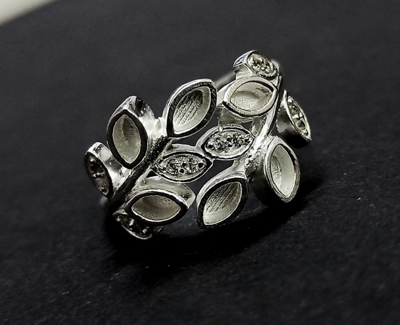K&ouml;nnte beinhalten: Silberring mit einem Blattdesign und klaren Steinen. Der Ring ist aus Metall gefertigt und hat einen zarten, femininen Look.