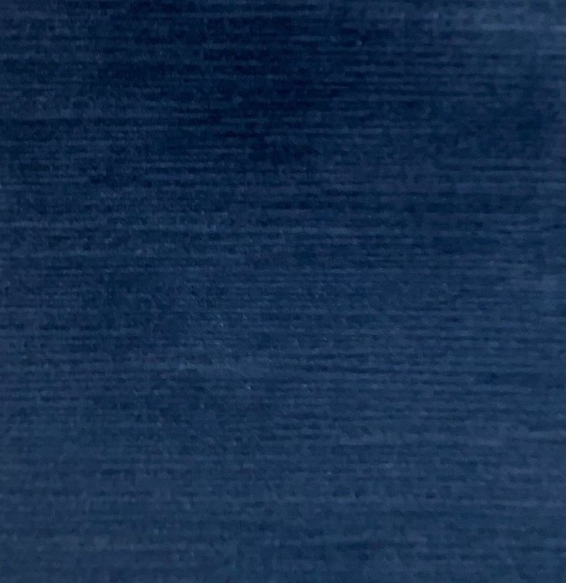 May include: A dark blue fabric with a subtle textured pattern. The fabric has a smooth, even surface and a rich, deep blue color.