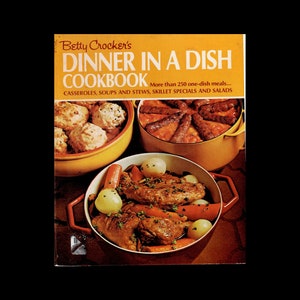 May include: A vintage cookbook titled "Betty Crocker's Dinner in a Dish Cookbook" with a yellow cover and a photo of three different dishes. The dishes are a casserole with dumplings, a casserole with sausage, and a casserole with chicken and vegetables.