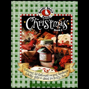 May include: A book cover with a red and white checkered background. The title is "Gooseberry Patch Christmas Book 3". The cover features a jar of homemade chocolate cookies, a red and white plaid fabric, and a red and white button.