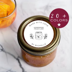 Pode incluir: Etiqueta redonda branca com texto preto e uma ilustração de um frasco. O texto diz "Made with Love Homemade Peach Jam By Michelle".