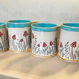 Tasse mit Waldpilzen auf handgemachter Keramik