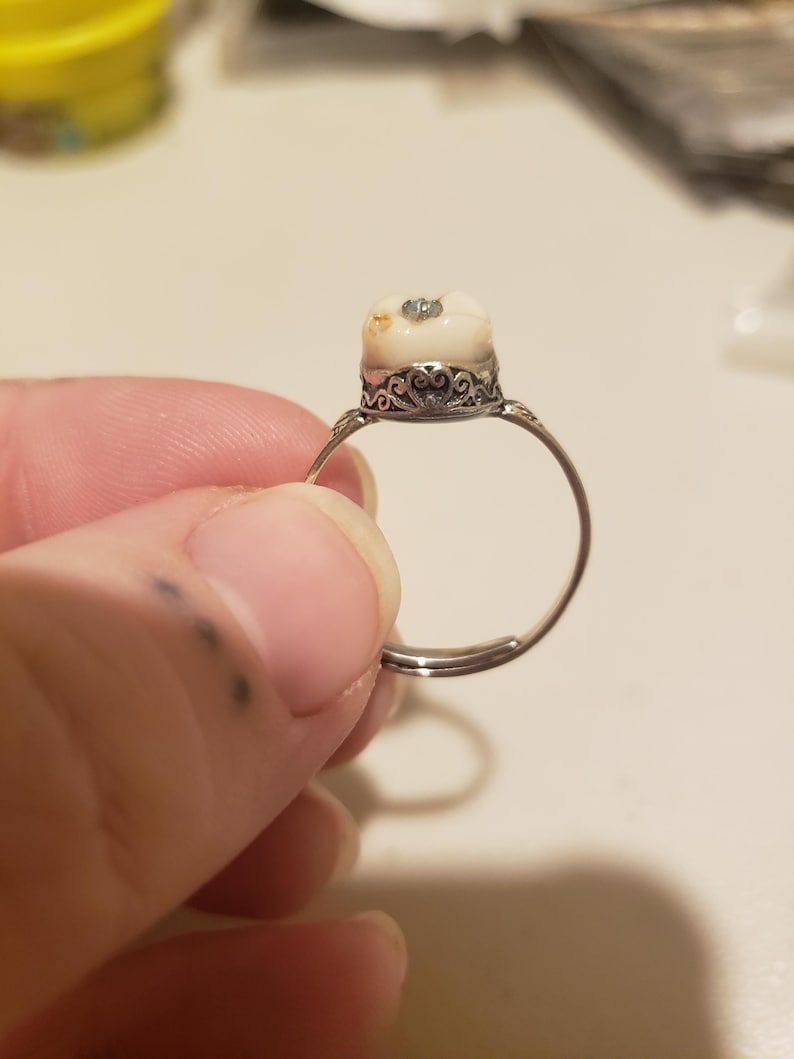 Baby tooth with any color gem. Thai silver band adjustable up to 13/14.