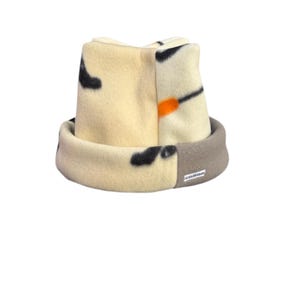 May include: A beige and grey fleece hat with a black and orange abstract pattern. The hat has a fold-over brim and a small label that says "AGARAWAN".