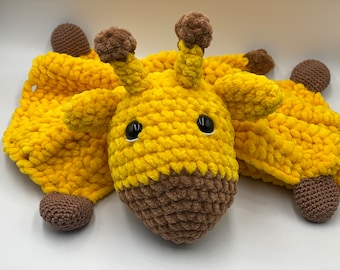 May include: A crocheted yellow and brown giraffe toy with a soft, plush texture. The giraffe has large, black eyes and a brown nose.