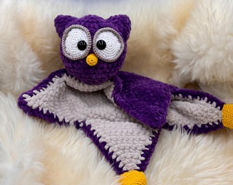 May include: Purple crocheted owl security blanket with a gray crocheted back and yellow feet.
