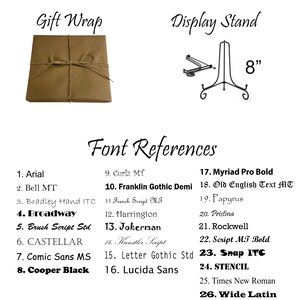 May include: A list of 26 fonts with their names and numbers. The fonts are displayed in a brown and white text on a white background. The image also shows a brown paper gift wrap and a black metal display stand with an 8-inch measurement.