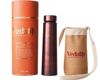 May include: A cylindrical orange storage tube with the text Vedalife Copper Water Bottle 950 ml, a dark metallic copper water bottle, and a beige burlap carrying pouch with a strap featuring the red Vedalife logo printed on the front.