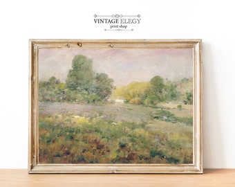 May include: A vintage landscape painting in a light wood frame. The painting depicts a field of green grass with trees in the background. The sky is a soft pink and blue.