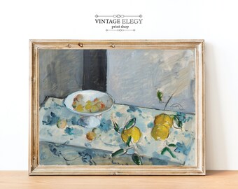 May include: A framed still life painting featuring a white pedestal bowl filled with fruit, and lemons on a patterned tablecloth. The painting has a gold frame and the text "VINTAGE ELEGY print shop" at the top.