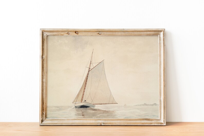 May include: A framed watercolor painting of a sailboat with white sails on a calm sea. The painting is in a light wood frame with a white mat.