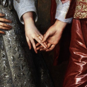 Pu&ograve; includere: Primo piano di due mani intrecciate, con un anello d'oro al dito della mano sinistra. Le mani sono vestite con abiti elaborati, una con un polsino di pizzo bianco e l'altra con una manica rossa e dorata.