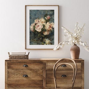 May include: A framed print of a still life painting featuring a bouquet of white roses in a vase against a blue background.