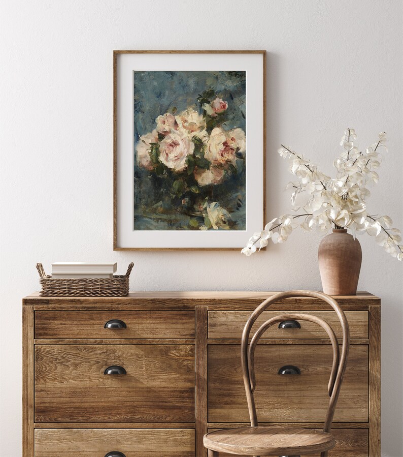 May include: A framed print of a still life painting featuring a bouquet of white roses in a vase against a blue background.