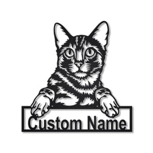 May include: A black metal wall art piece featuring a detailed cat silhouette with its front paws resting on a rectangular frame. The frame contains the text Custom Name in a bold, sans-serif font, creating a personalized decorative sign.