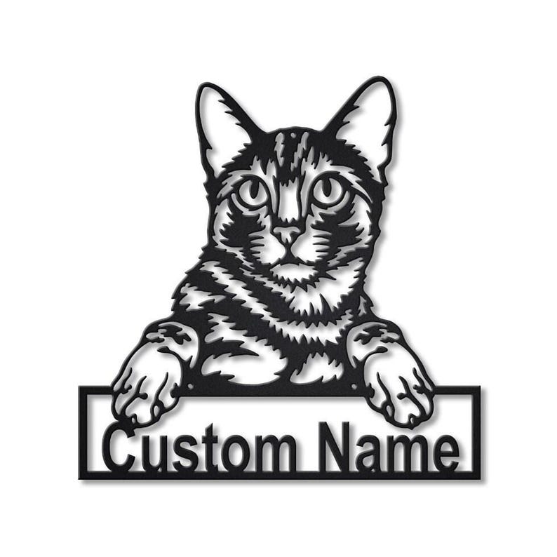May include: A black metal wall art piece featuring a detailed cat silhouette with its front paws resting on a rectangular frame. The frame contains the text Custom Name in a bold, sans-serif font, creating a personalized decorative sign.