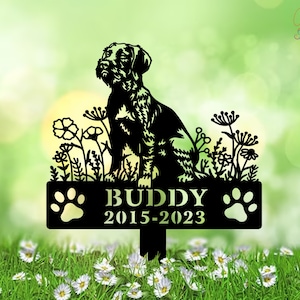 Könnte beinhalten: Schwarzer Garten-Gedenkstein aus Metall mit einer Silhouette eines Hundes, Blumen und dem Text "BUDDY 2015-2023".